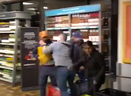 Em uma captura de tela do vídeo postado no X, um espectador de camisa cinza confronta dois homens e uma mulher durante um roubo em um LCBO em Etobicoke.